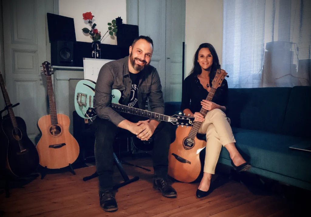 Anna et Jean-Christophe assis avec leurs guitares dans la salle de cours de Longueau